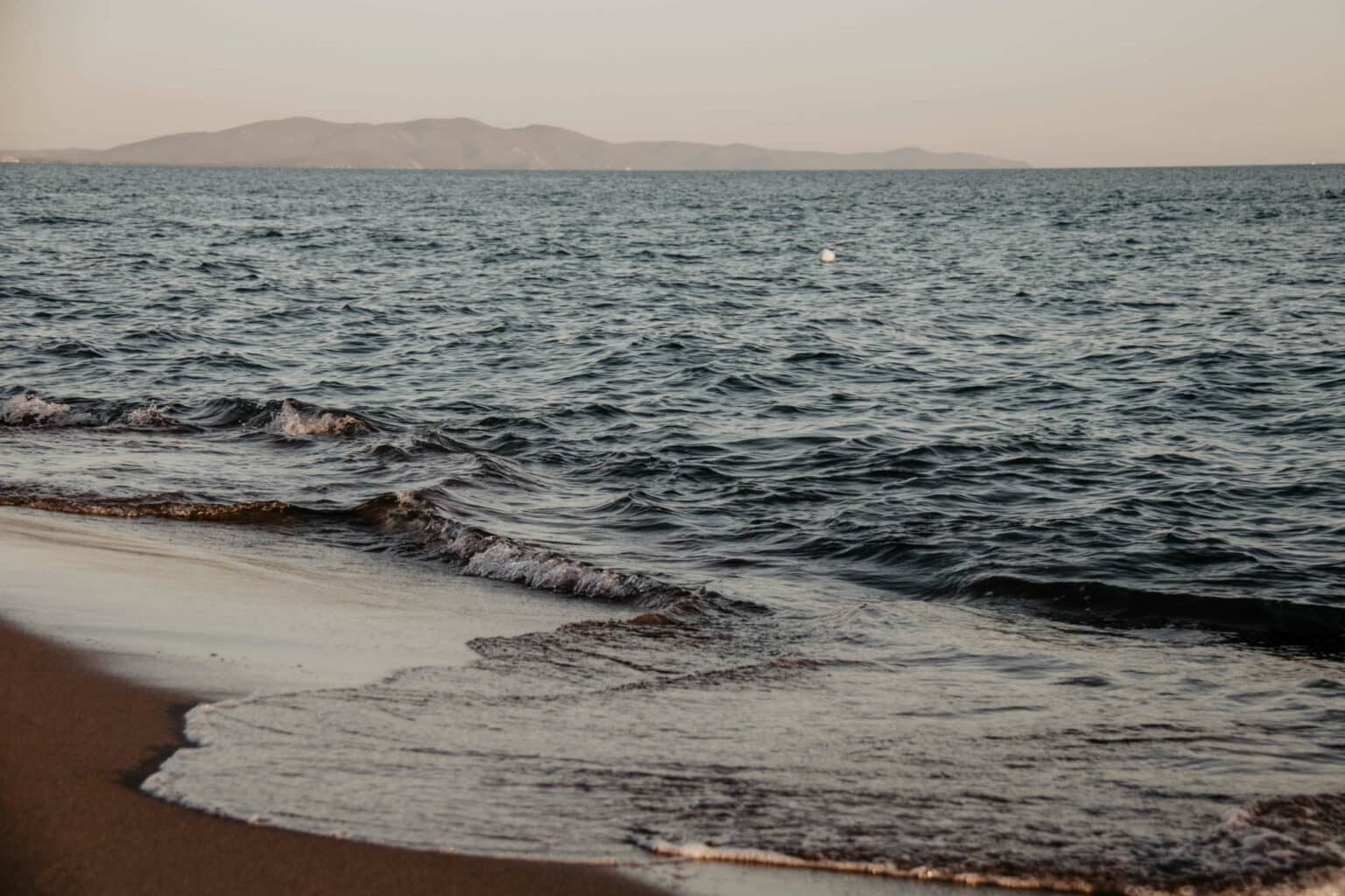 Sanfte Wellen werden an den Strand gespült.