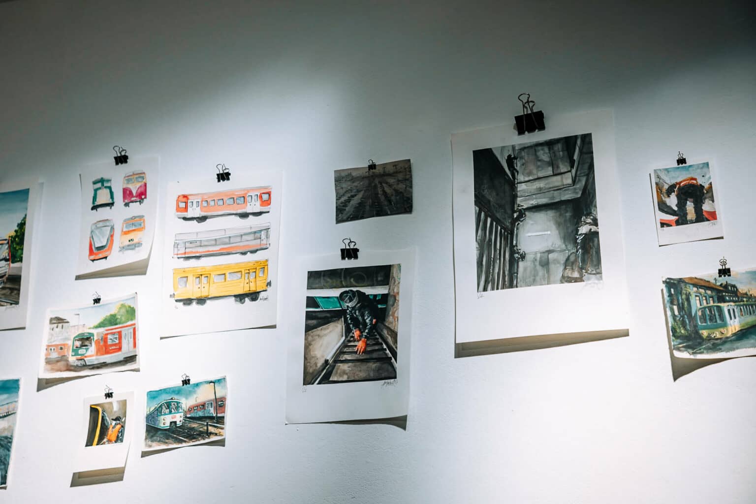 Verschiedene Kunstwerke auf Blättern an der Wand in der K-OZ Galerie in Hamburg.
